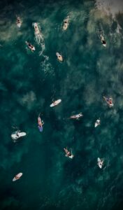 Aerial view of surfers in the vibrant waters of Brisas de Zicatela, Mexico, capturing summer adventure.